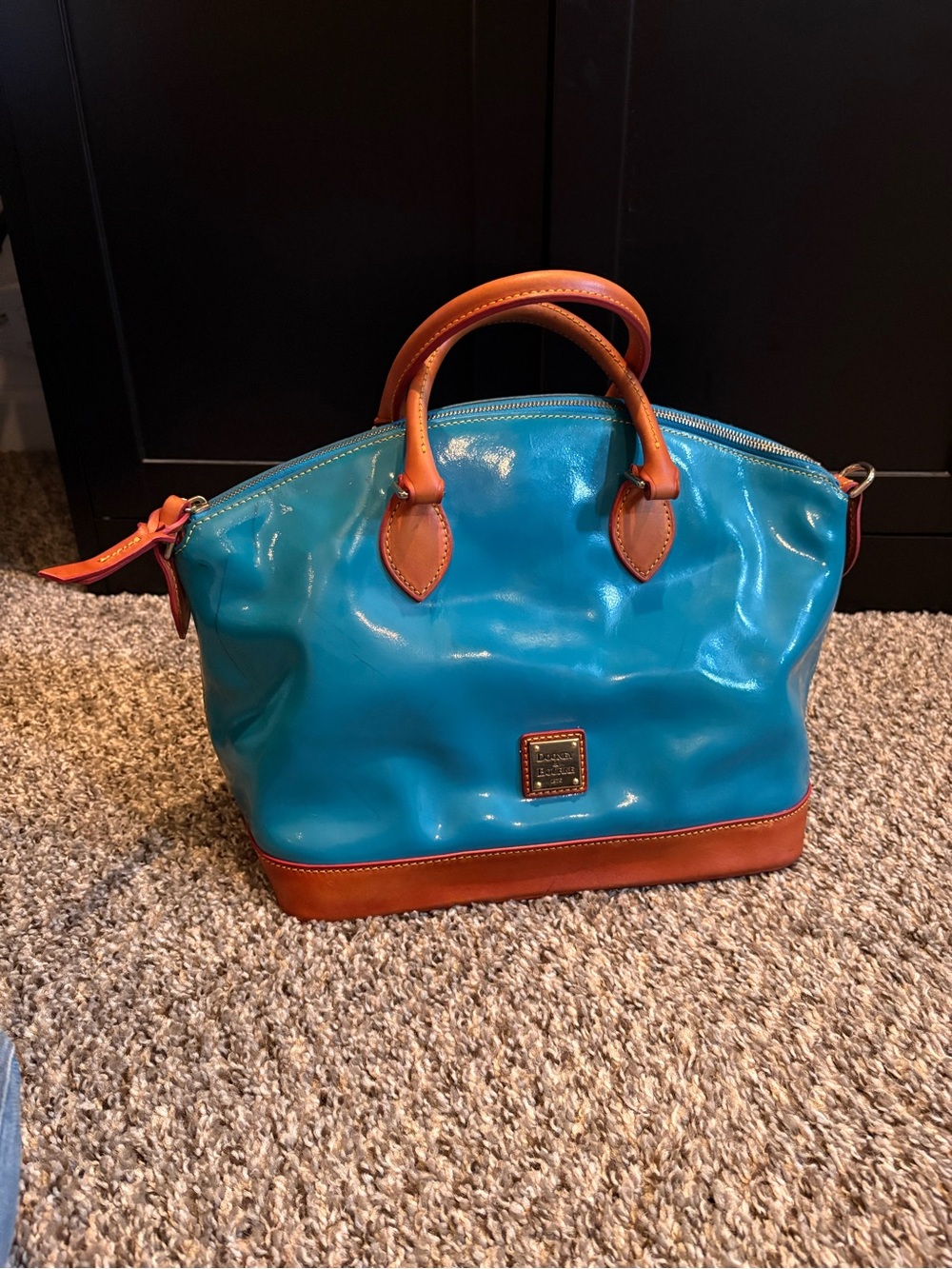 This is a Dooney & Bourke Darcy Teal Patent Leather Satchel handbag.